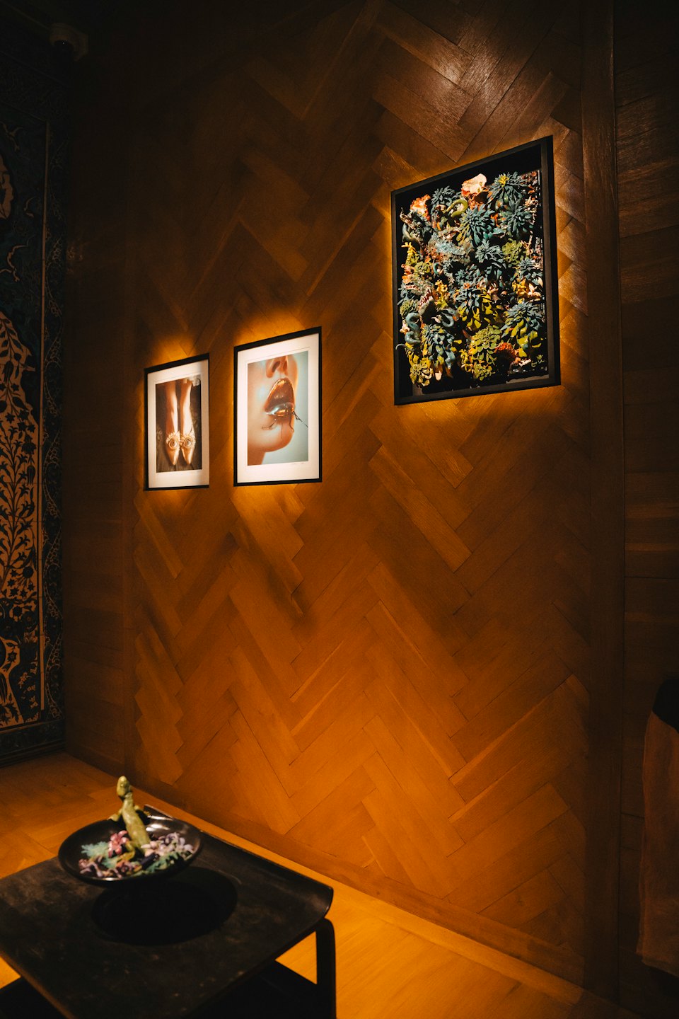 Herringbone wood walls with art and a table display.