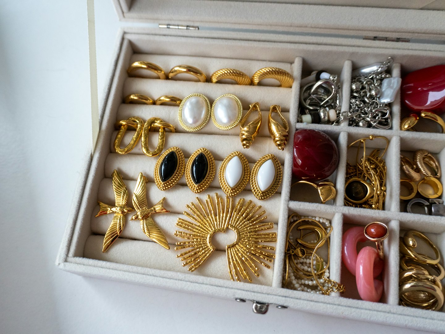 Vintage gold jewelry displayed inside a light velvet box.